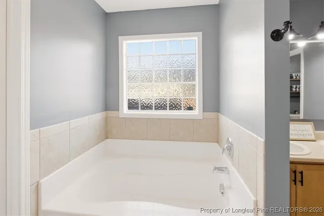 a white bath tub sitting in a bathroom next to a window