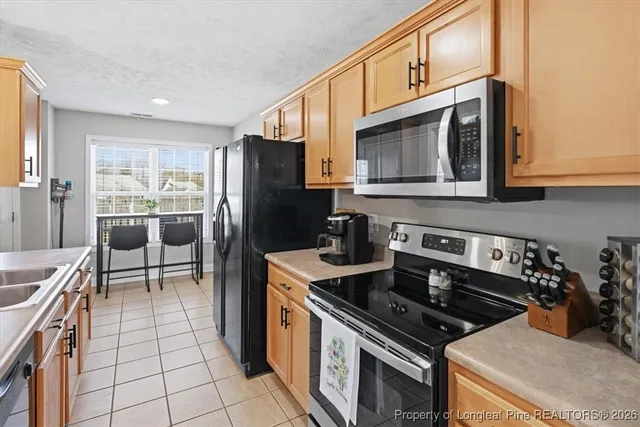 a kitchen with a stove a microwave and refrigerator