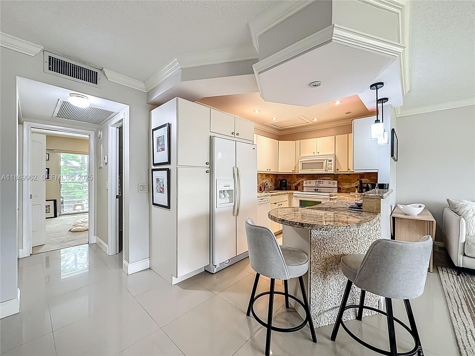 618 Fanshaw O, Unit 618 Boca Raton, FL 33434 - Photo 16 of 40 a kitchen with stainless steel appliances kitchen island granite countertop a refrigerator and a stove