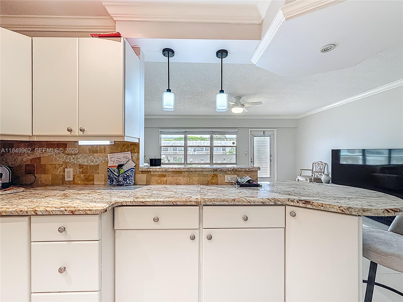 618 Fanshaw O, Unit 618 Boca Raton, FL 33434 - Photo 19 of 40 a kitchen with granite countertop a sink stainless steel appliances white cabinets and a granite counter top