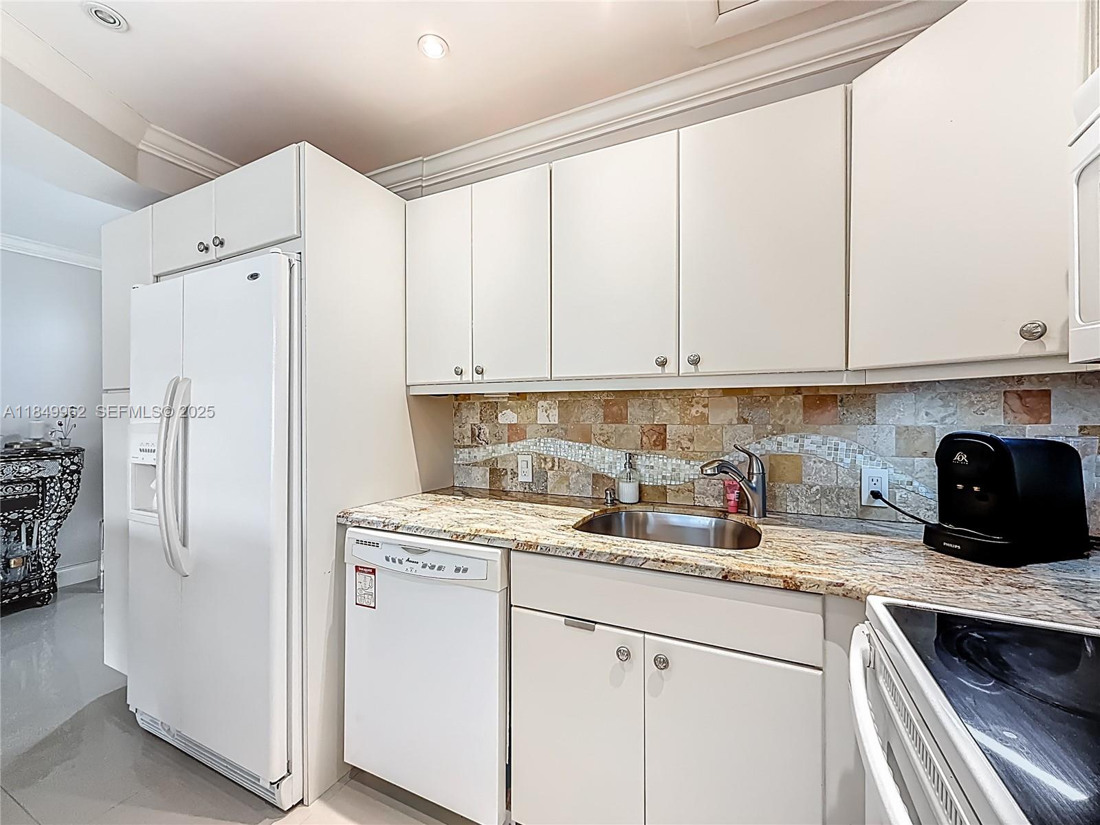 618 Fanshaw O, Unit 618 Boca Raton, FL 33434 - Photo 21 of 40 a kitchen with stainless steel appliances granite countertop a refrigerator sink and white cabinets
