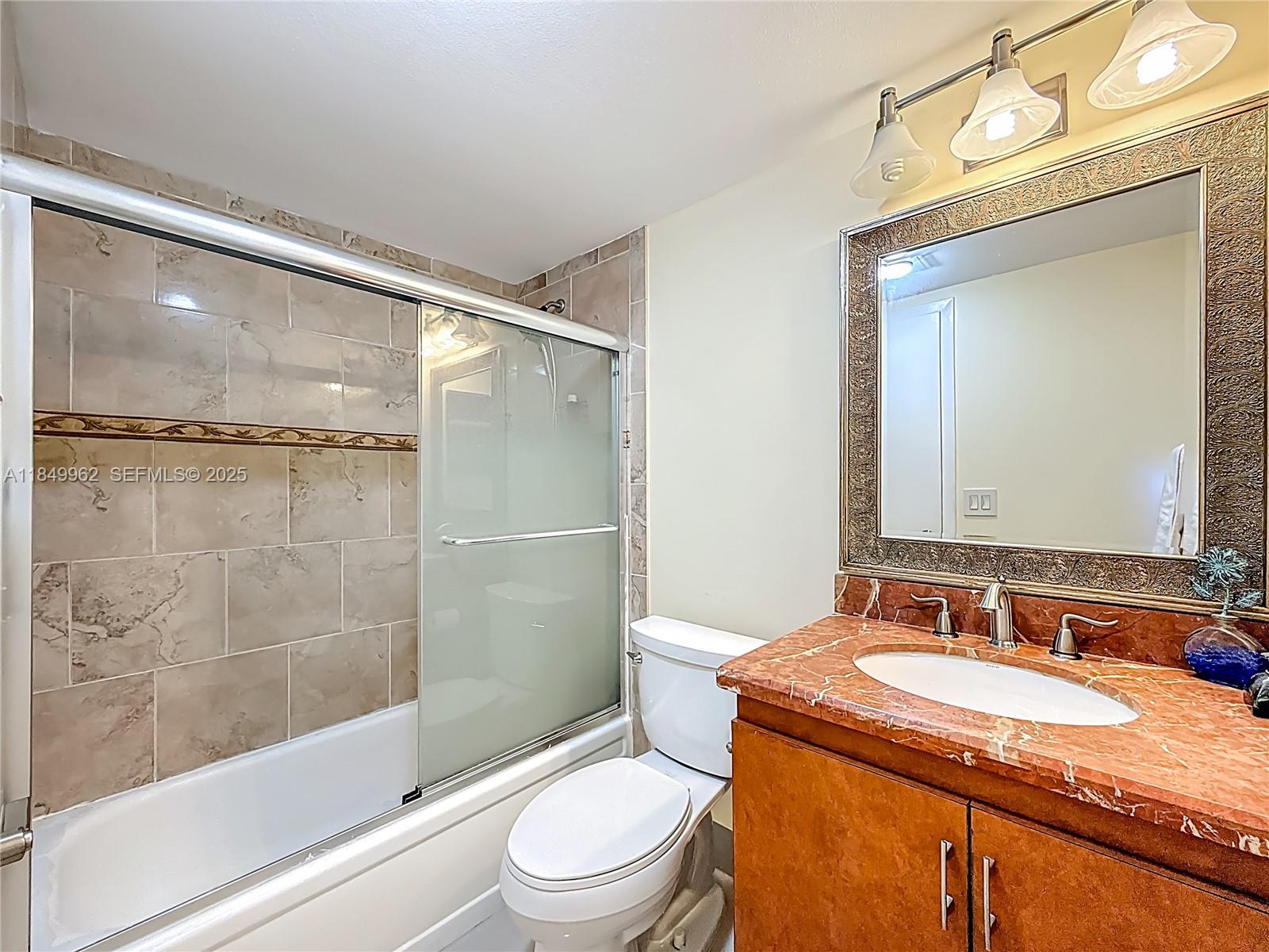 618 Fanshaw O, Unit 618 Boca Raton, FL 33434 - Photo 23 of 40 a bathroom with a granite countertop sink toilet and shower