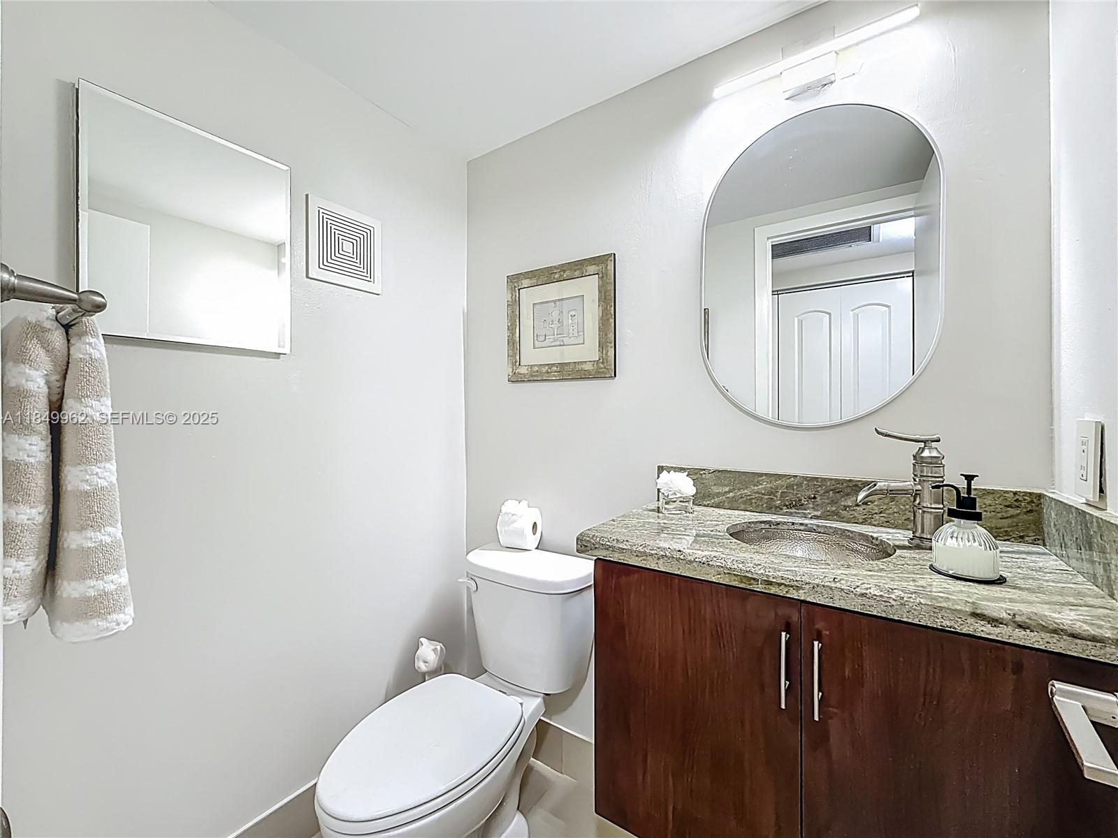 618 Fanshaw O, Unit 618 Boca Raton, FL 33434 - Photo 29 of 40 a bathroom with a granite countertop toilet sink mirror and vanity