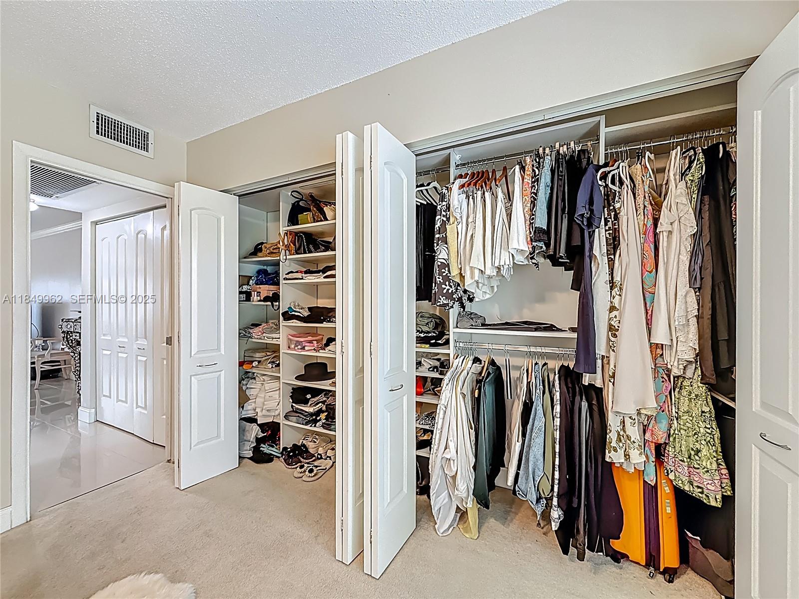 618 Fanshaw O, Unit 618 Boca Raton, FL 33434 - Photo 30 of 40 a view of walk in closet with clothes and shoes