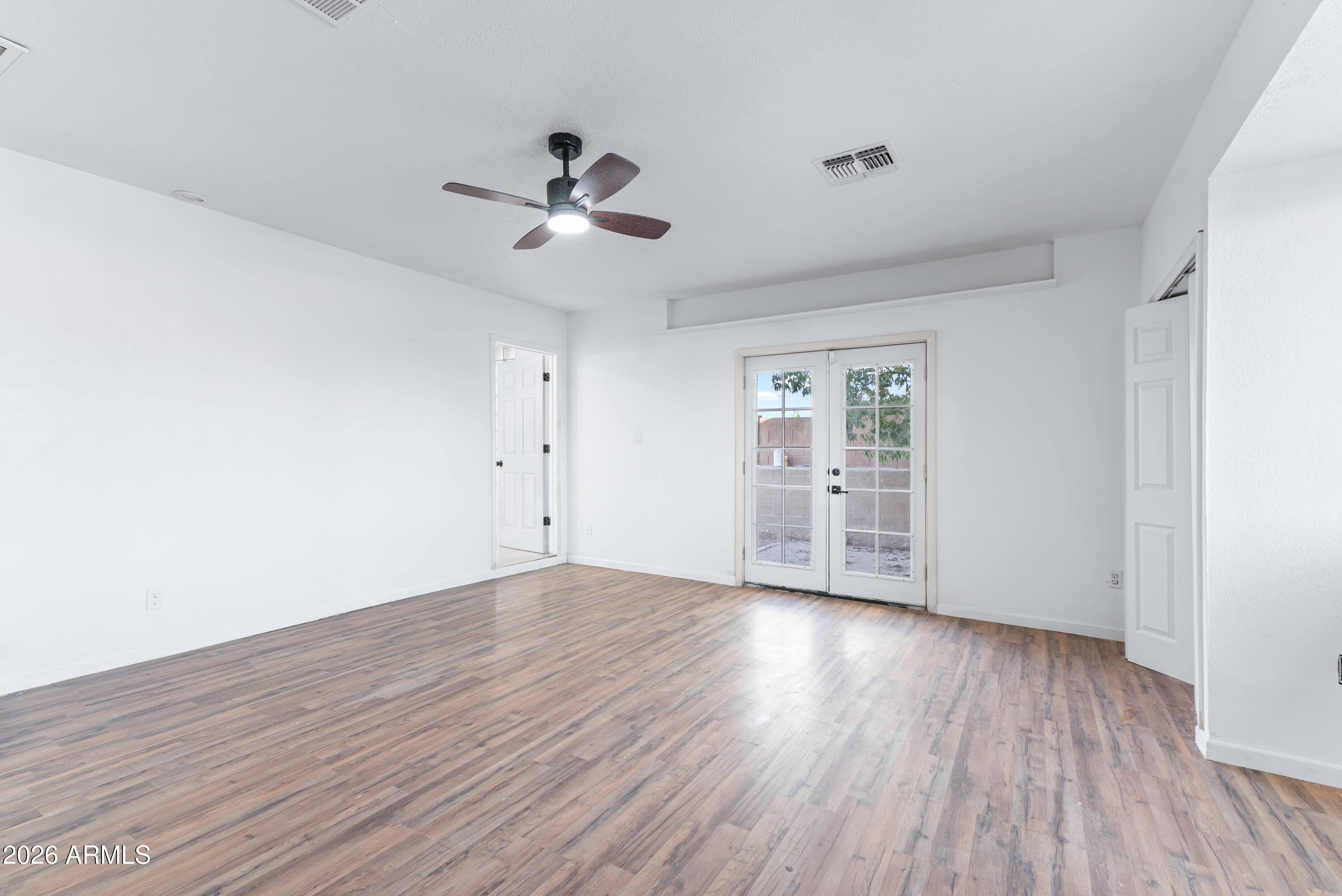 860 West McLellan Road Mesa, AZ 85201 - Photo 8 of 26 a view of an empty room with a window and wooden floor