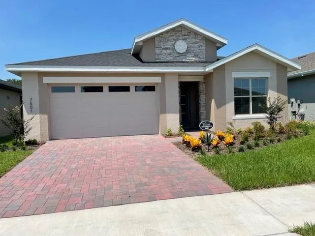a front view of a house with a garden and yard