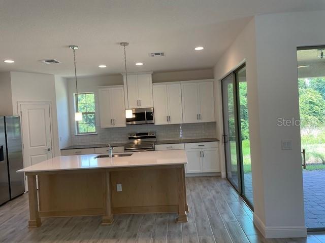 7501 Wing Span Way Harmony, FL 34773 - Photo 4 of 30 a kitchen with a refrigerator and a sink
