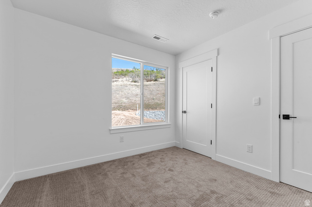 1341 West 2350 South, Unit 10 Perry, UT 84302 - Photo 14 of 18 Carpeted room featuring a large window, contemporary white trim, and two paneled doors with matte black hardware