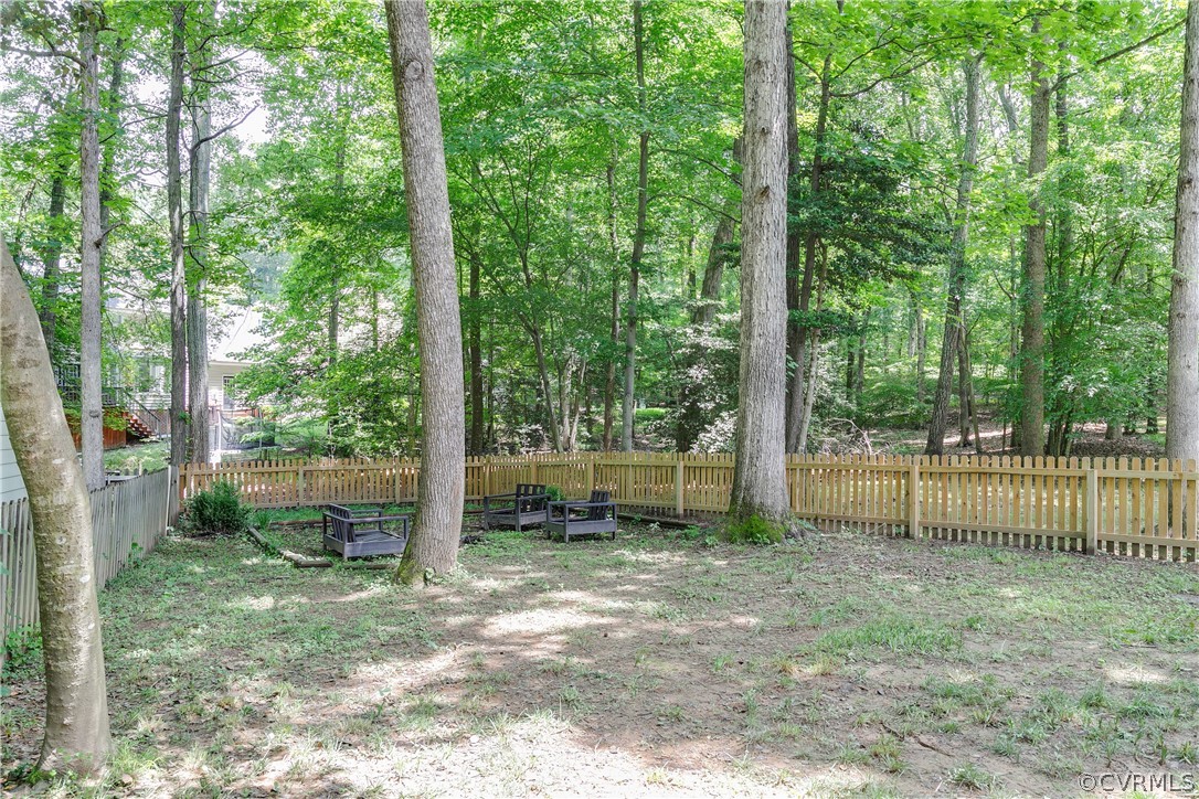 5615 Chatmoss Road Midlothian, VA 23112 - Photo 33 of 41 a backyard of a house with large trees and plants