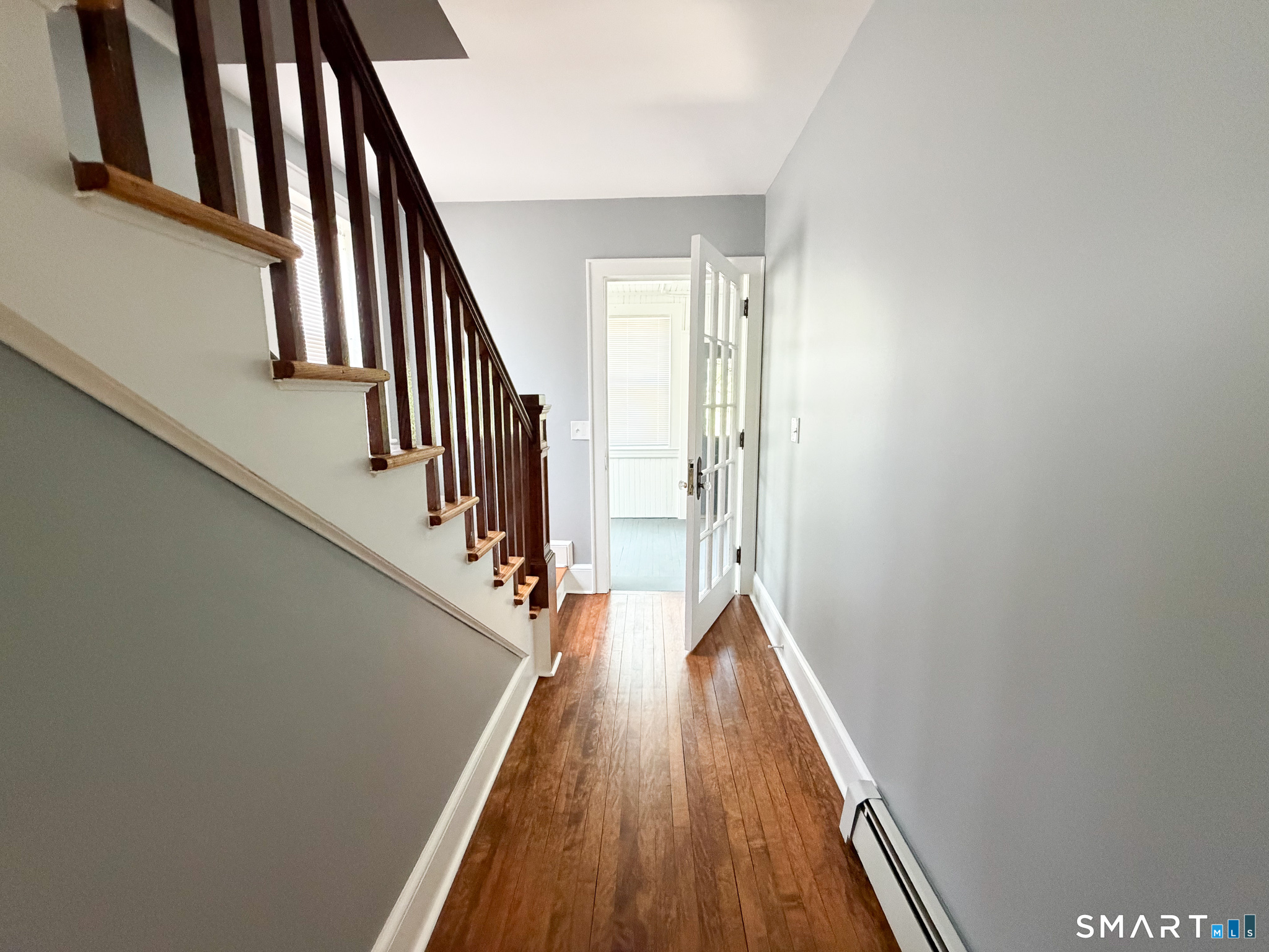 793 Milford Point Road, Unit 1 Milford, CT 06460 - Photo 14 of 16 a view of a hallway with wooden floor and staircase
