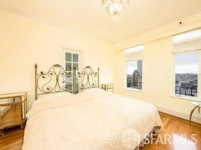 a spacious bedroom with a large bed and a chandelier