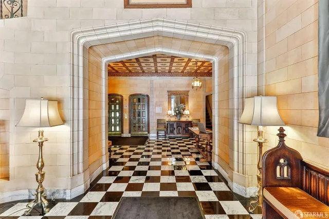 a living room with a black white checkered floor with couches chair and a coffee table
