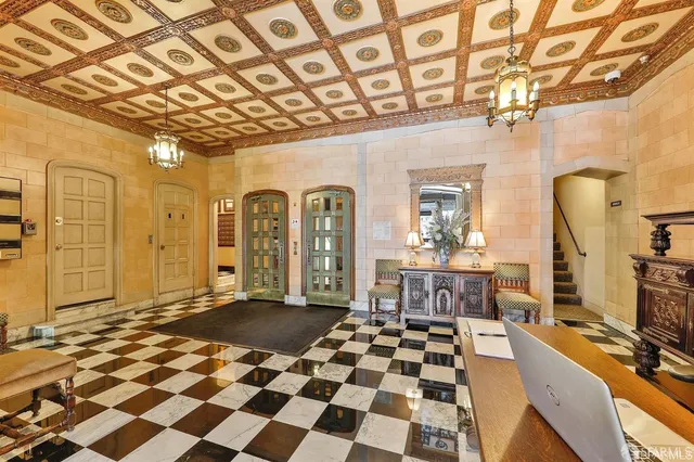 a living room with a black white checkered floor with couches next to a dining table and a stove top oven