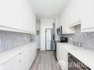 a kitchen with a sink a refrigerator and cabinets