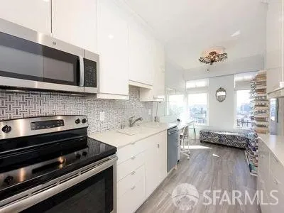 a kitchen with stainless steel appliances a stove a sink and a microwave
