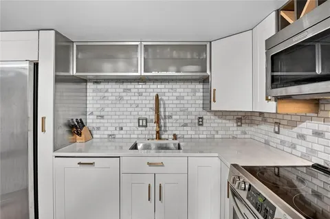 a kitchen with cabinets stainless steel appliances and a sink