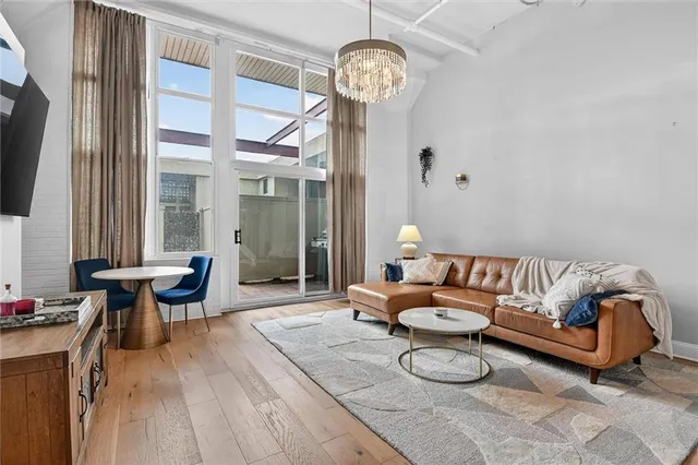 a living room with furniture a large window and a chandelier
