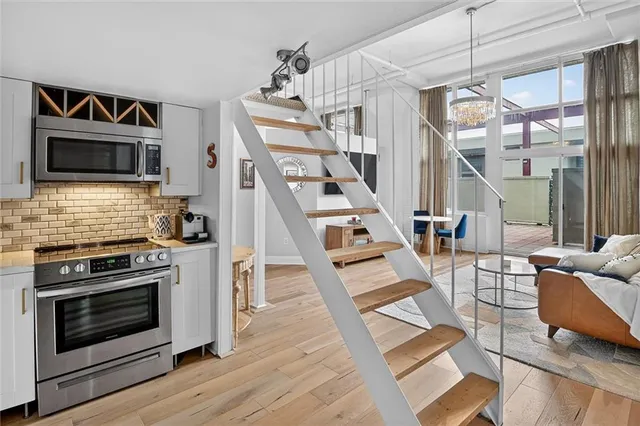 a kitchen with stainless steel appliances granite countertop a stove a sink and a microwave