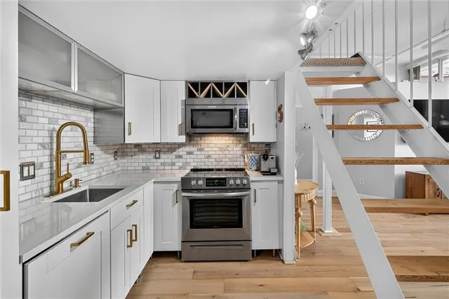 a kitchen with stainless steel appliances white cabinets and a sink