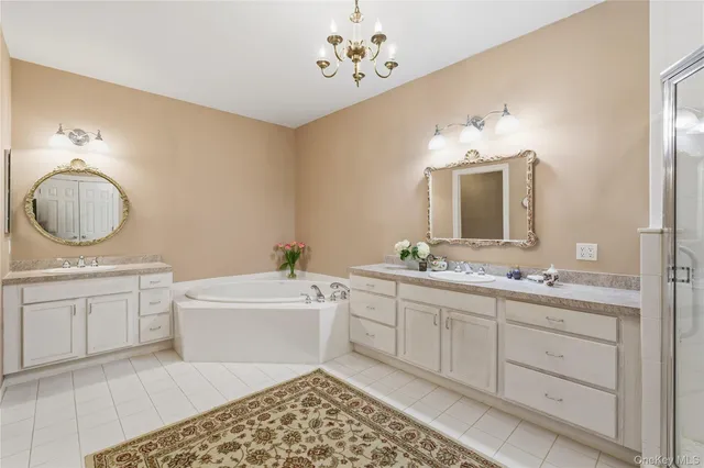a spacious bathroom with a double vanity sink mirror and a bathtub