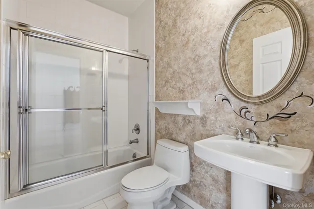 a bathroom with a sink toilet and a mirror