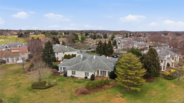 an aerial view of a house with a yard and lake view
