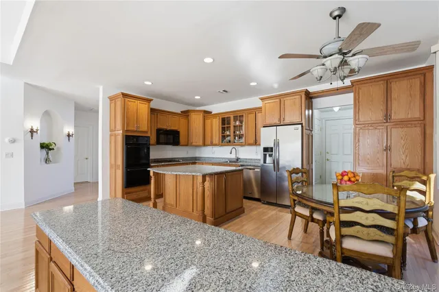 a kitchen with stainless steel appliances granite countertop a refrigerator a sink a stove and island