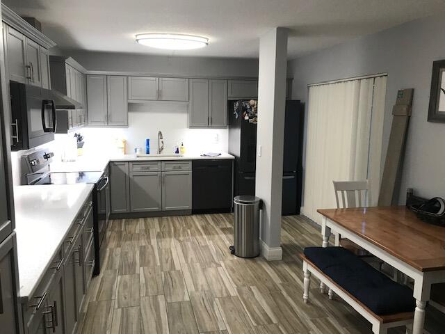 825 Center Street, Unit 1B Jupiter, FL 33458 - Photo 5 of 16 a kitchen with kitchen island stainless steel appliances a sink stove and refrigerator