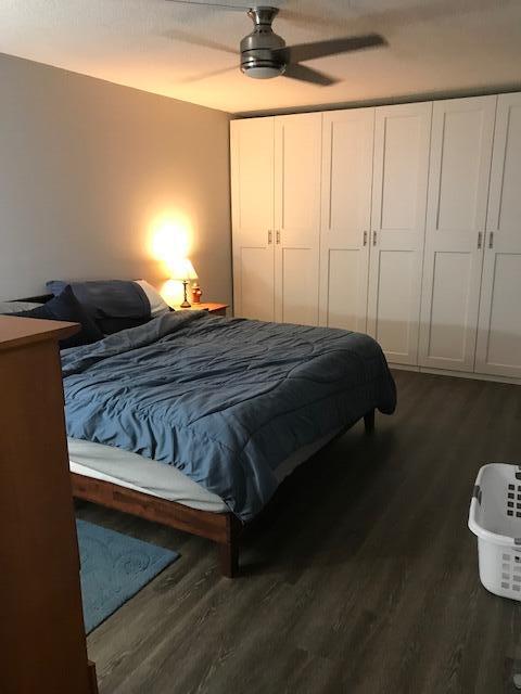 825 Center Street, Unit 1B Jupiter, FL 33458 - Photo 8 of 16 a bedroom with a bed and a chandelier