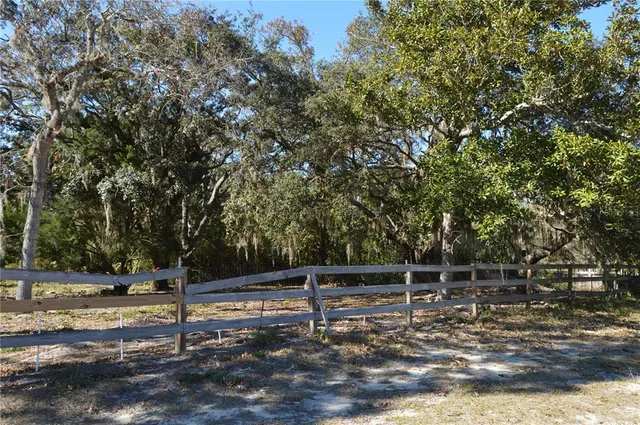 a view of a yard with wooden fence