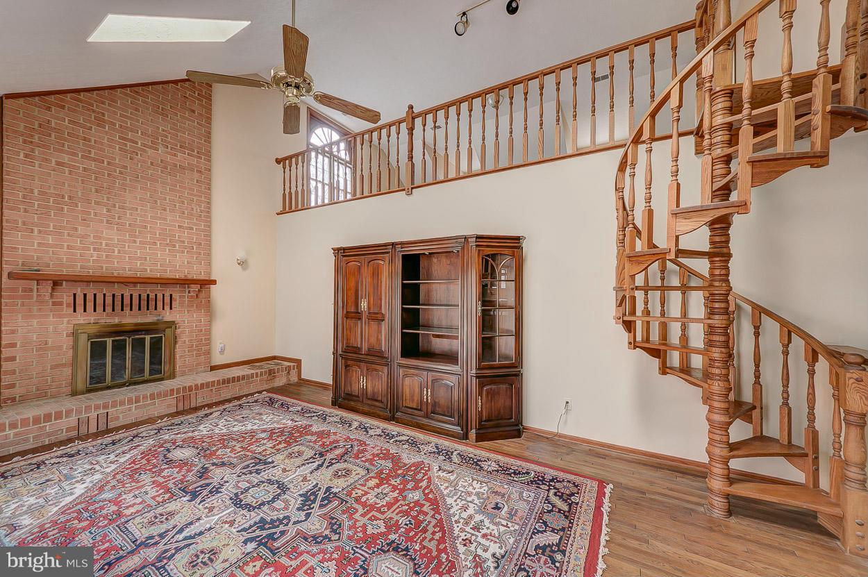 15710 Yeoho Road Sparks, MD 21152 - Photo 11 of 30 a view of a livingroom with wooden floor staircase and a kitchen space