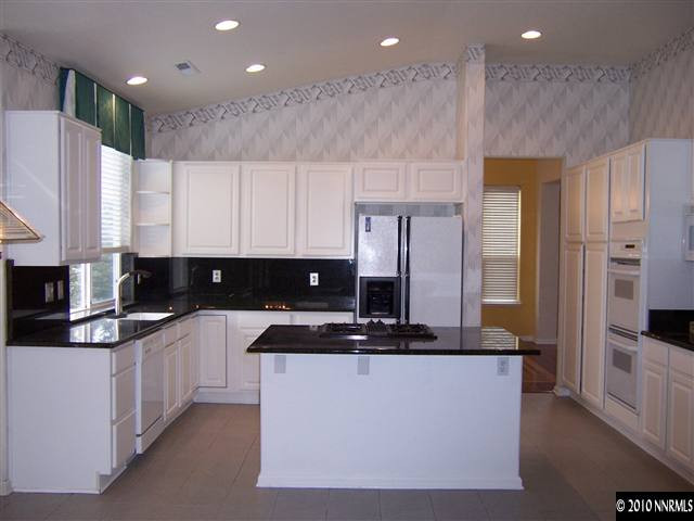 4819 Elkcreek Trail Reno, NV 89519 - Photo 3 of 9 a kitchen with stainless steel appliances granite countertop a stove a sink and a refrigerator