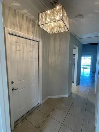 an empty room with wooden floor and chandelier