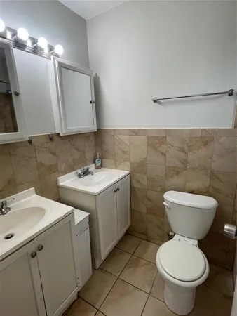 a bathroom with a toilet sink and mirror