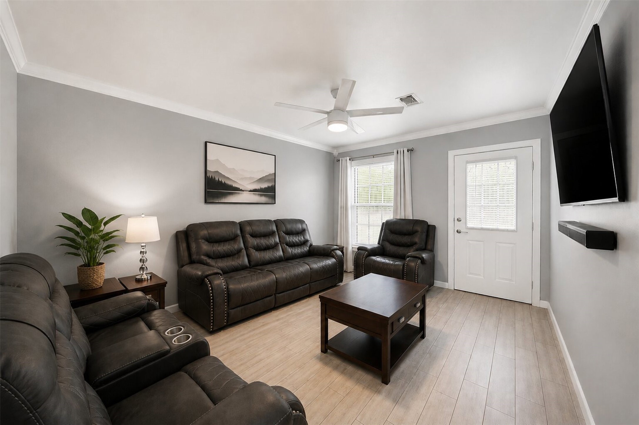 1306 Camden Road Pasadena, TX 77502 - Photo 3 of 16 Bright and inviting living room featuring crown molding, a ceiling fan, and large windows that fill the space with natural light, perfect for relaxing or entertaining guests!