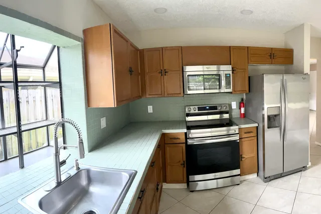 a kitchen with stainless steel appliances granite countertop a refrigerator and a stove top oven