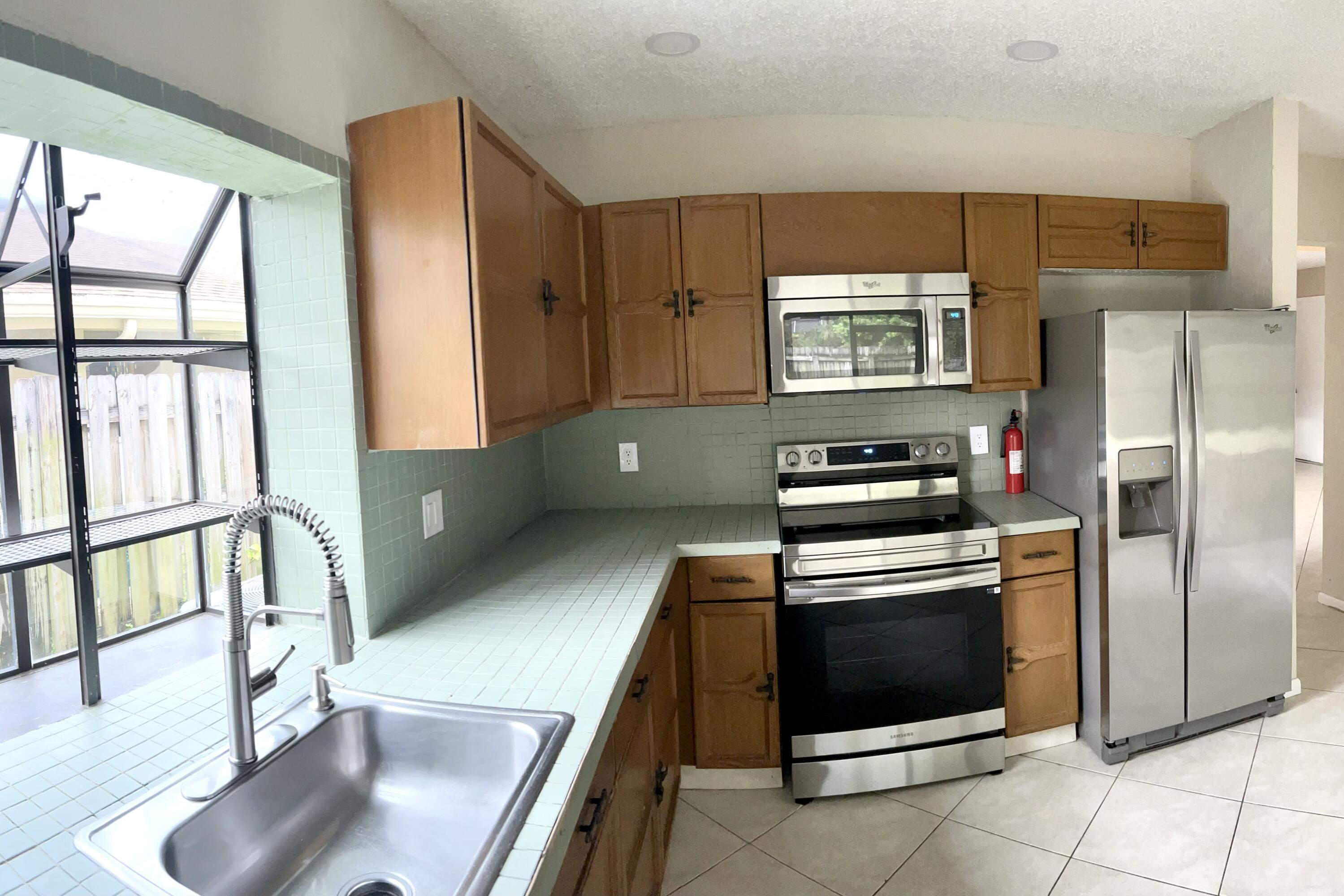 7614 Sierra Terrace West Boca Raton, FL 33433 - Photo 14 of 20 a kitchen with stainless steel appliances granite countertop a refrigerator and a stove top oven