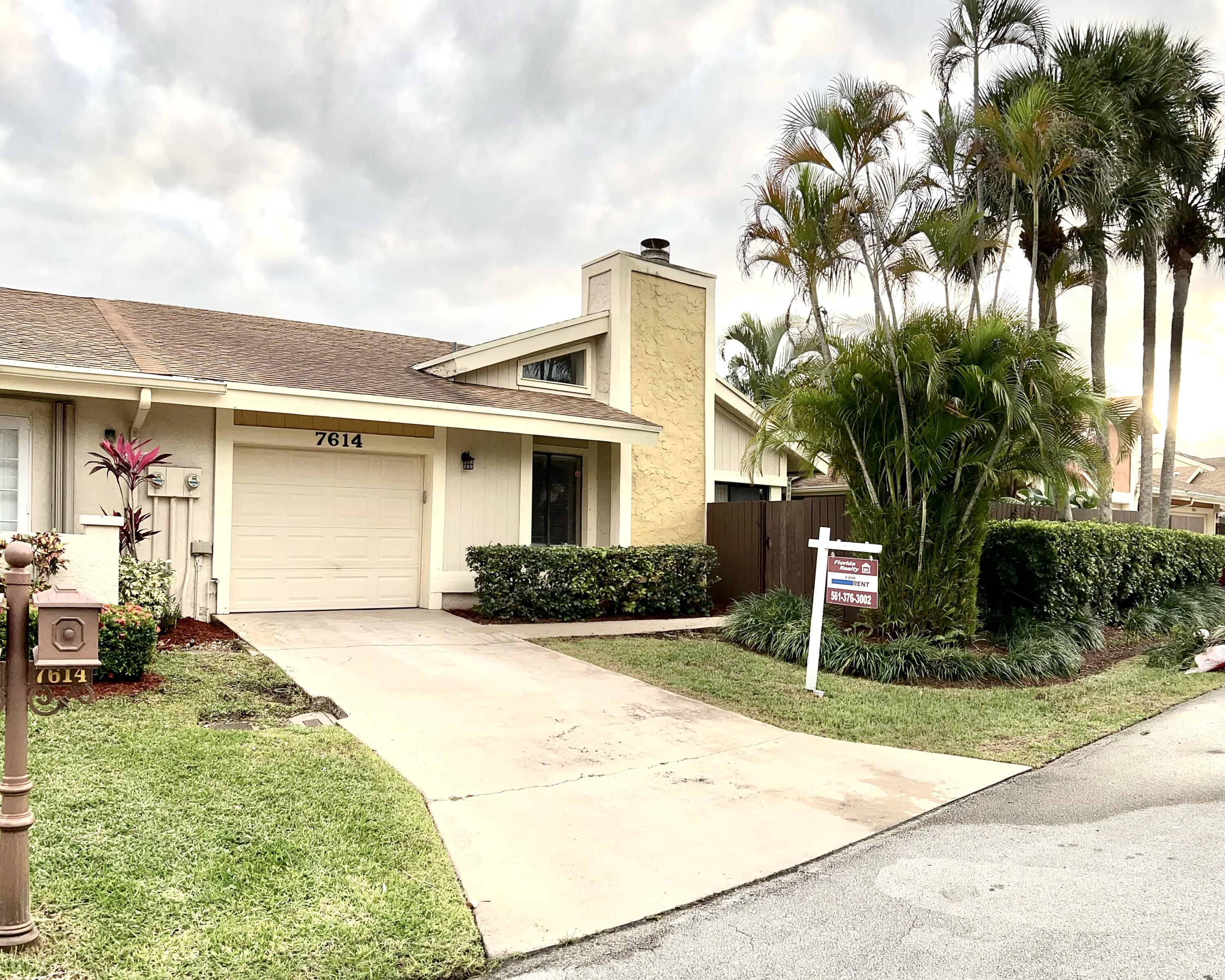 7614 Sierra Terrace West Boca Raton, FL 33433 - Photo 2 of 20 a front view of a house with a yard and potted plants