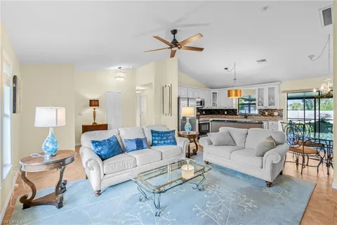 a living room with furniture and a view of kitchen