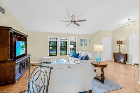a living room with furniture a flat screen tv and a window