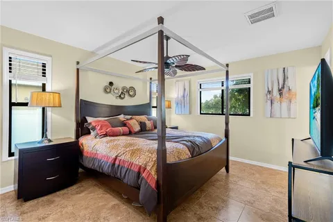 a bedroom with a bed window and a flat screen tv
