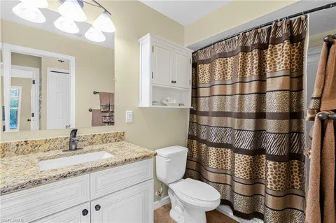 a bathroom with a granite countertop toilet sink and shower