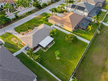 an aerial view of a residential houses with yard