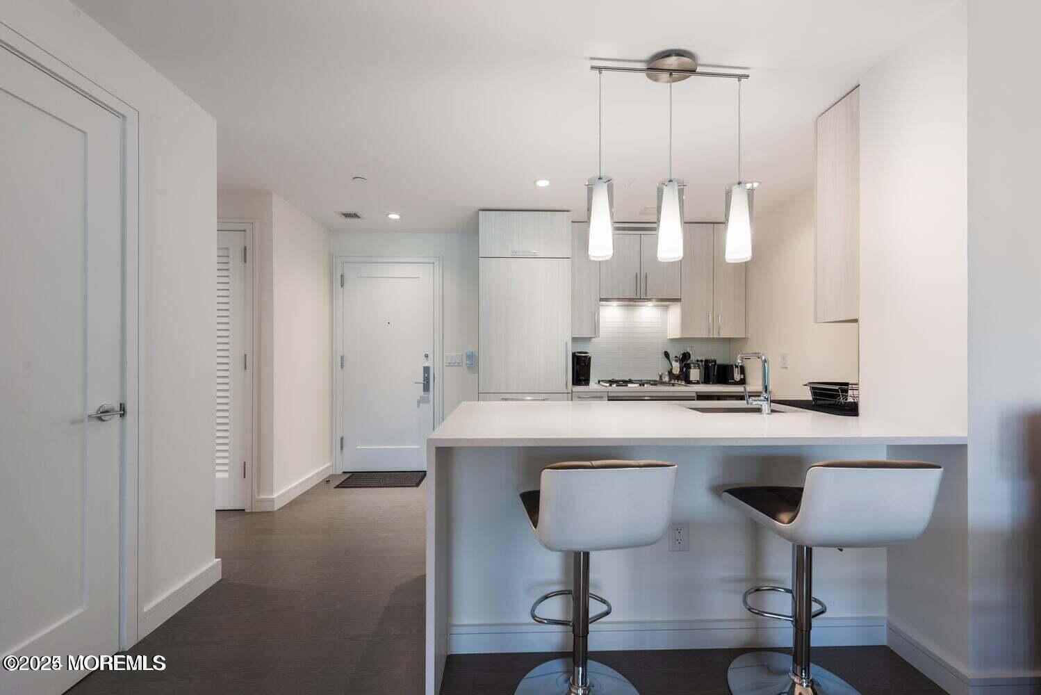 15 Morris Avenue, Unit 308 Long Branch, NJ 07740 - Photo 3 of 48 a view of a kitchen with a sink a refrigerator and chairs