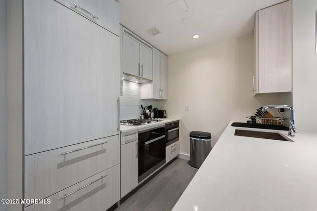 a kitchen with white cabinets and appliances