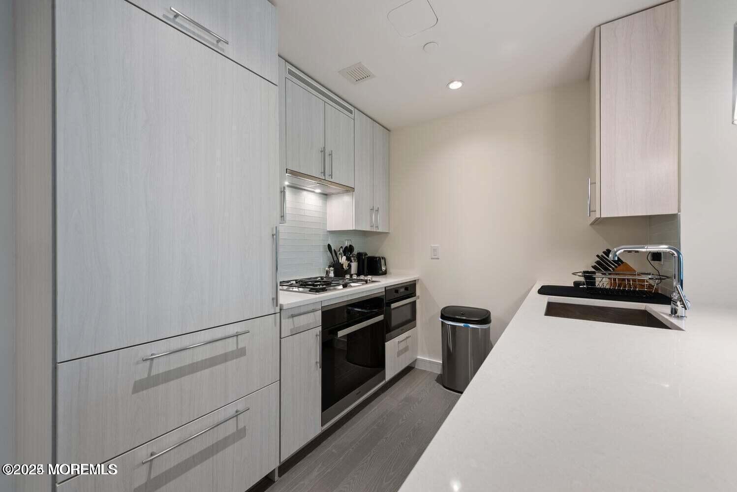 15 Morris Avenue, Unit 308 Long Branch, NJ 07740 - Photo 4 of 48 a kitchen with white cabinets and appliances