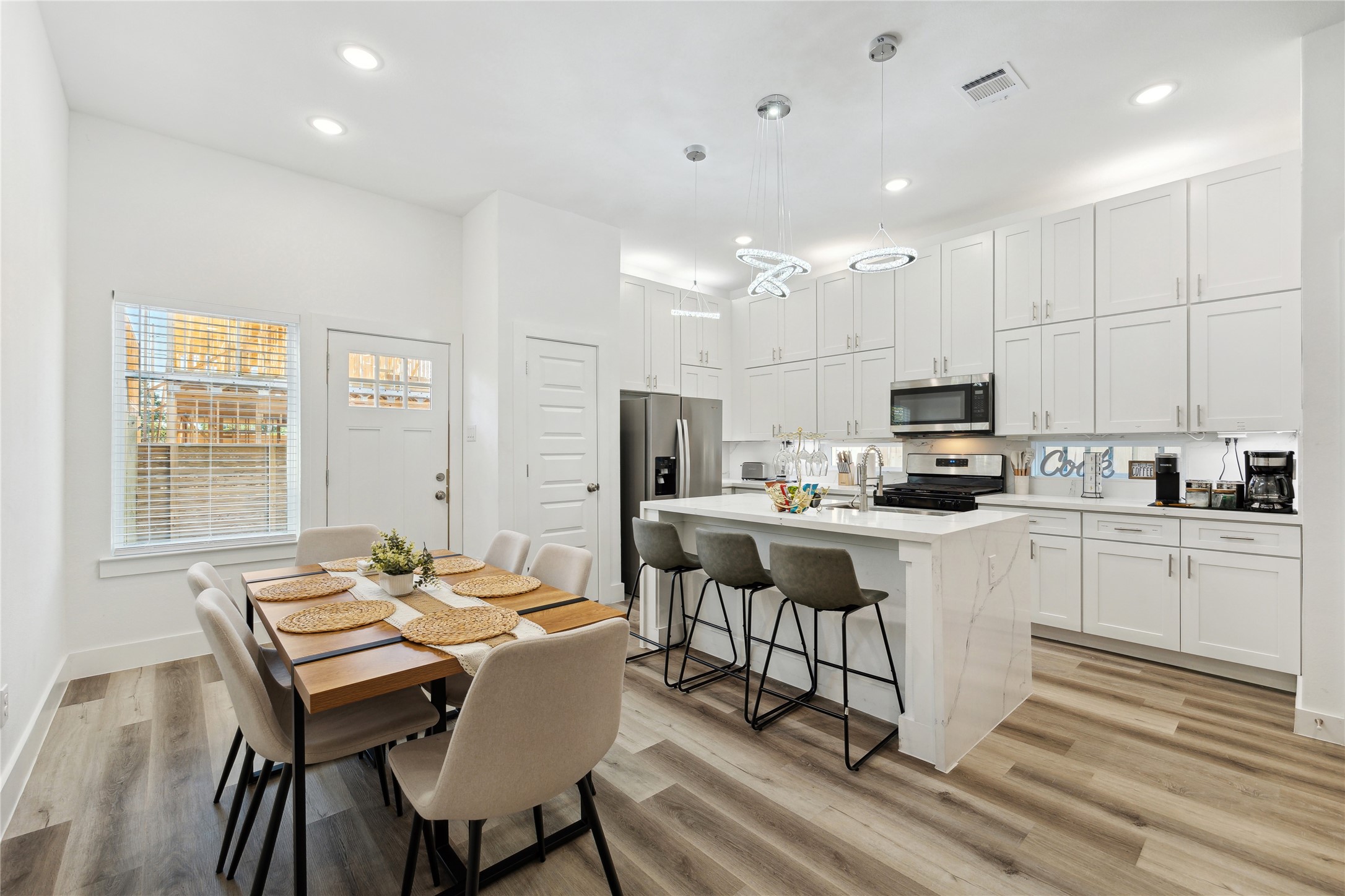 3828 Noah Street, Unit B Houston, TX 77021 - Photo 3 of 10 a kitchen with kitchen island granite countertop a dining table chairs refrigerator and cabinets