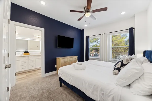 a bedroom with a bed a window and a flat screen television