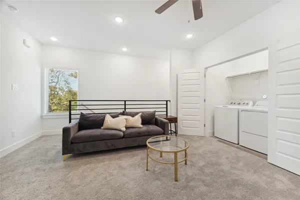 a living room with furniture and a ceiling fan