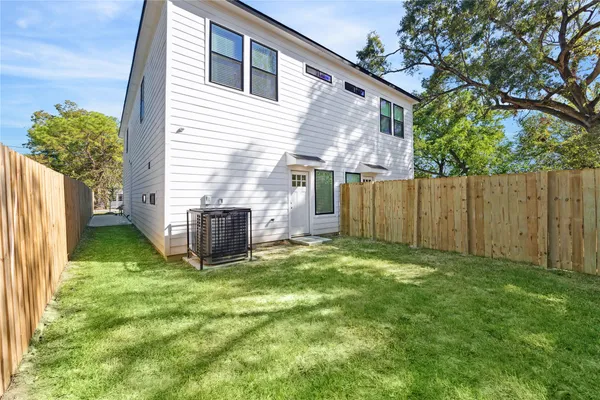 a view of a house with backyard and a tree